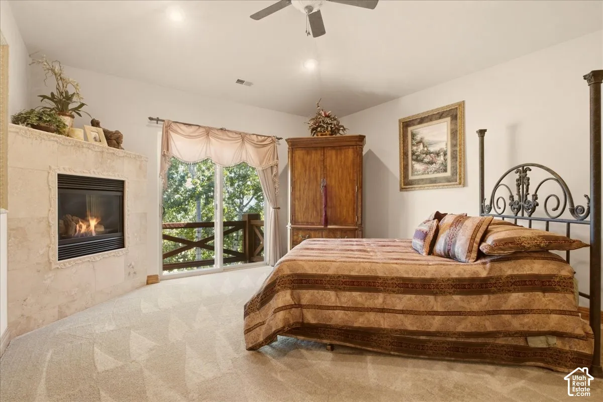Owner's suite featuring a built-in fireplace, and a balcony with wooden railings