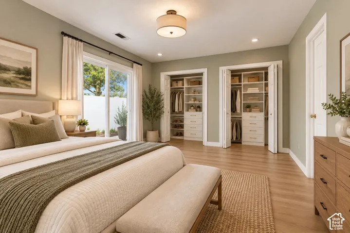 Wood-finish flooring, two built-in closet systems with shelving and drawers, recessed lighting, and a sliding glass door to exterior
