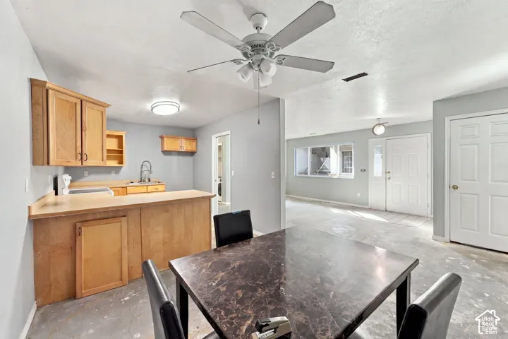 Kitchen featuring wood cabinetry, stainless steel sink with gooseneck faucet, and breakfast bar