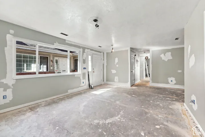 Spacious interior with neutral walls, white trim, and a prominent front-facing window