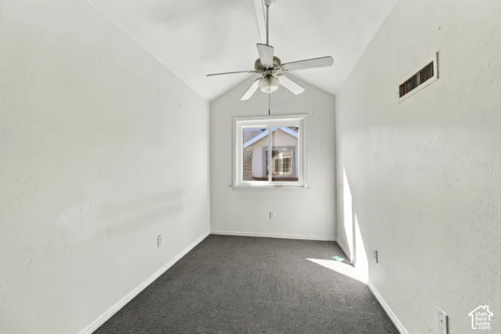 Vaulted ceiling with a ceiling fan, single window, and textured walls