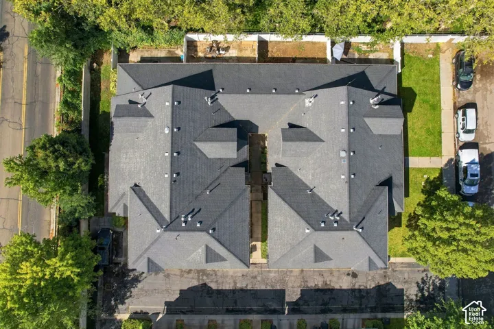 Property with dark gray shingle roofs, multiple roof lines, and surrounding mature trees
