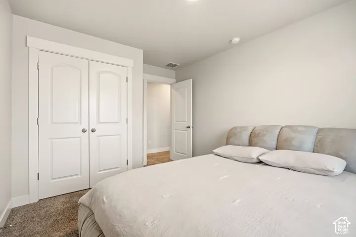 Neutral wall color, arched panel closet doors, white trim, and carpeted flooring