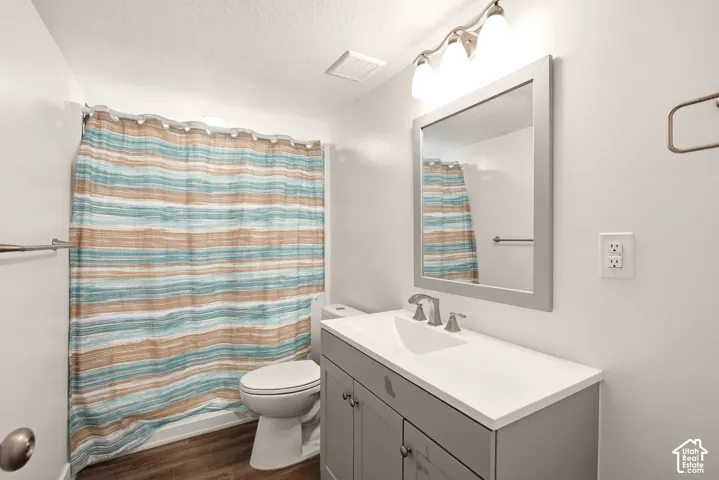 Vanity with integrated sink, rectangular framed mirror, and chrome wall sconce lighting
