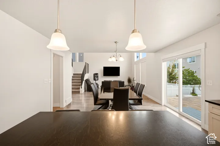 Open-concept interior featuring pendant lighting, wood-finish flooring, and a sliding glass door