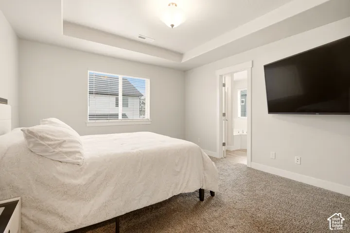 Recessed ceiling detail, neutral-toned walls, and plush carpet flooring