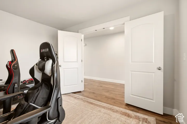 White interior walls with white trim, wood-finish flooring, and white two-panel interior doors