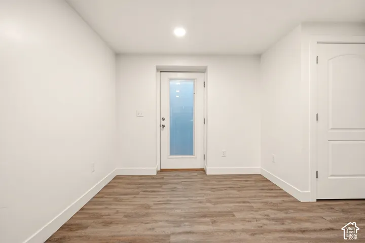 Wood-finish flooring, recessed ceiling lighting, and crisp white walls