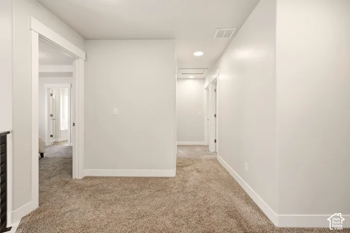 Neutral wall paint, recessed lighting, and carpet flooring throughout