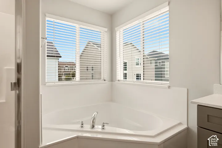 Corner soaking tub with polished chrome fixtures and two windows