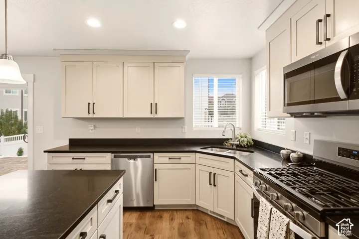 Kitchen featuring recessed lighting, a stainless steel gas range, microwave, dishwasher, and dark countertops
