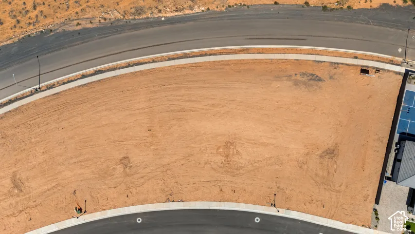 Graded lot with an adjacent paved road and concrete sidewalk