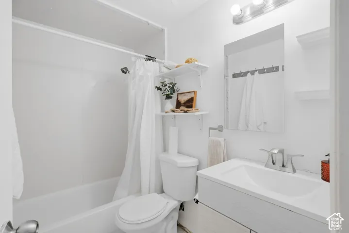 White vanity with a single basin sink and chrome faucet