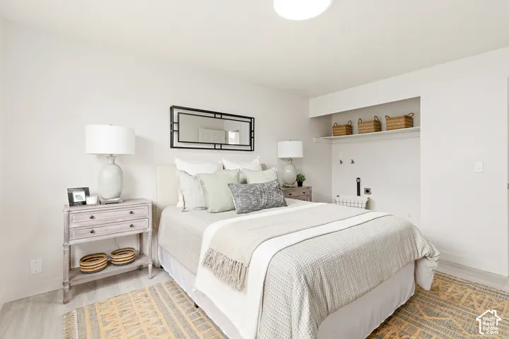 Light wood-finish flooring, recessed alcove with built-in shelving, and a prominent ceiling light fixture