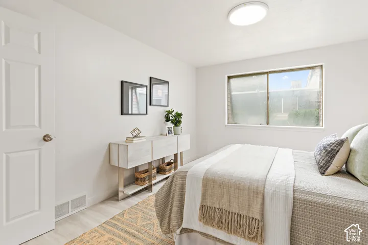 Recessed lighting, white paneled door, light wood-finish flooring, white walls, and a built-in window