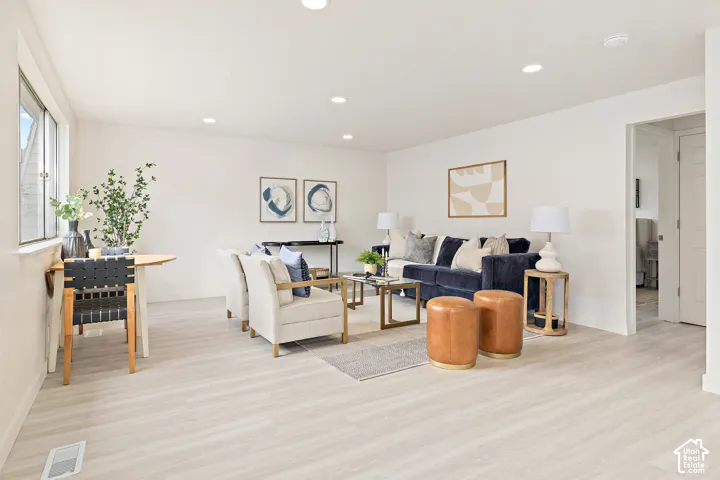 White walls, recessed lighting, and wood-finish flooring
