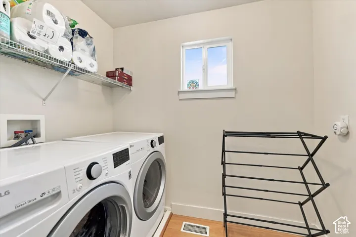 Laundry area featuring a window, wood-finish flooring, and a wire shelf