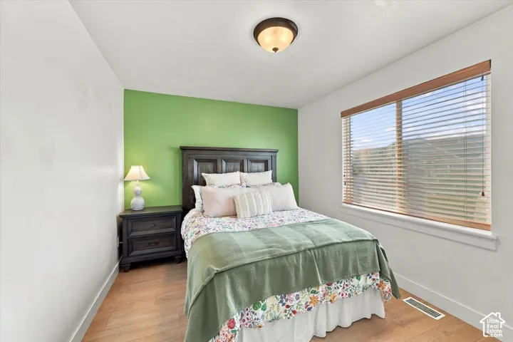 Recessed window with horizontal blinds, wood-finish flooring, and a flush-mount ceiling light fixture