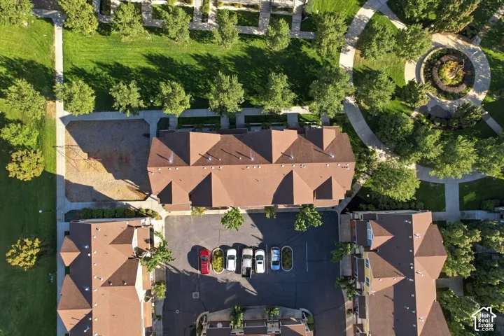 Community featuring multiple buildings with gabled roofs, ample green space, paved walkways, and a central circular landscape element