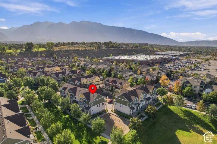 Aerial perspective of this residential property situated in a tree-lined neighborhood, featuring manicured landscaping, mature vegetation throughout the grounds, and a distinctive architectural footprint