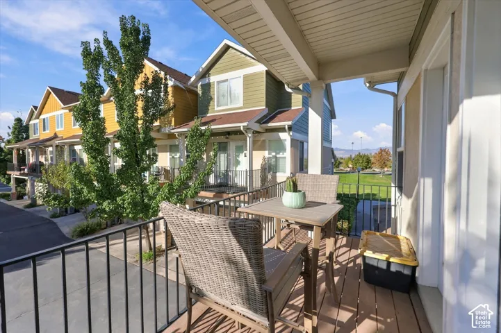 Covered balcony featuring wood-finish decking and black metal railing