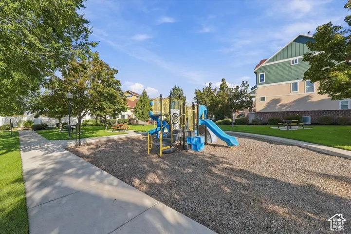 Community playground featuring a blue slide and climbing elements, surrounded by a wood chip surface