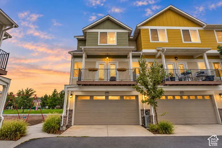 Two-story townhome with private balconies, attached garages, and a distinctive multi-color facade