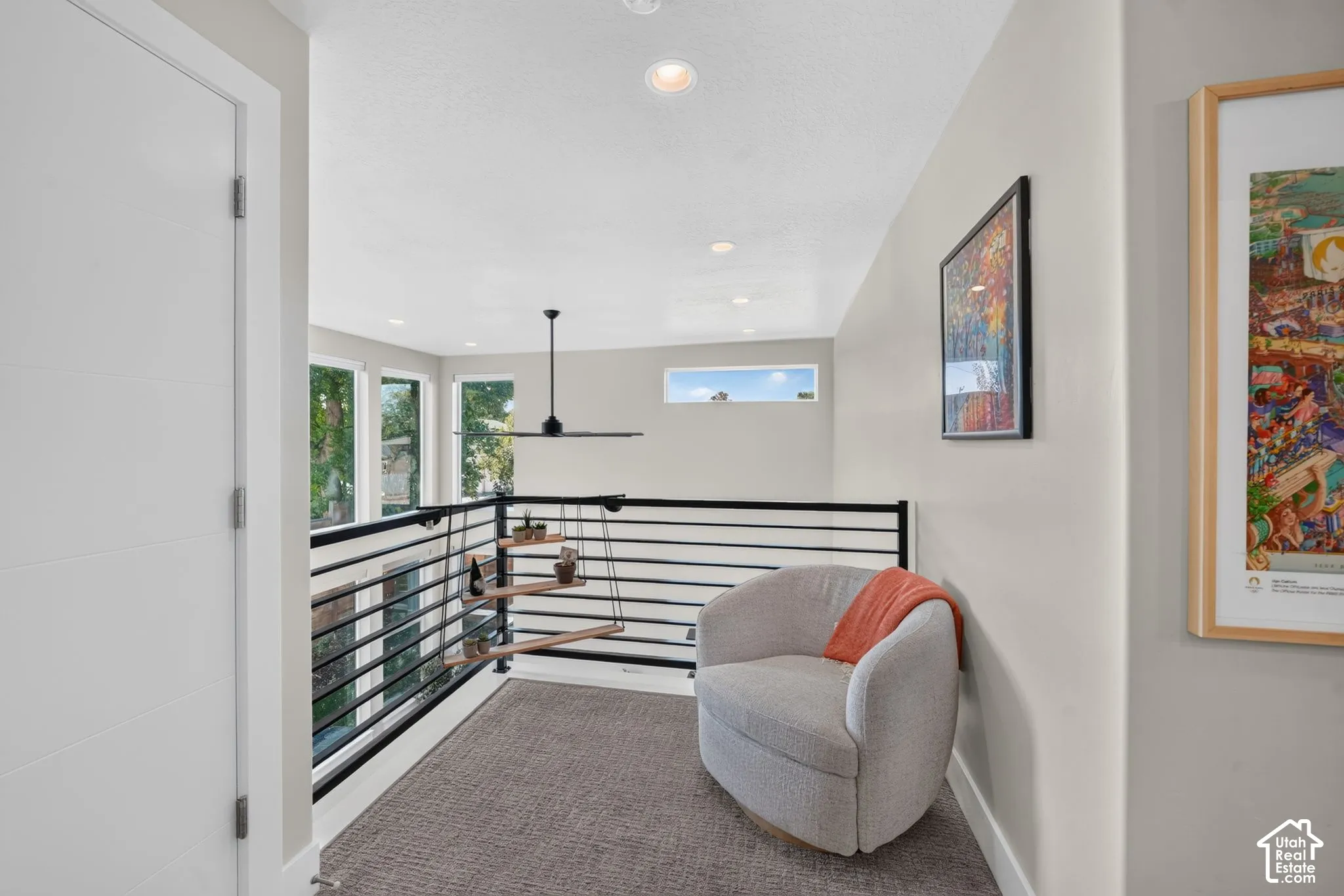Upper-level landing featuring a contemporary horizontal railing, recessed lighting, and views into open concept living space