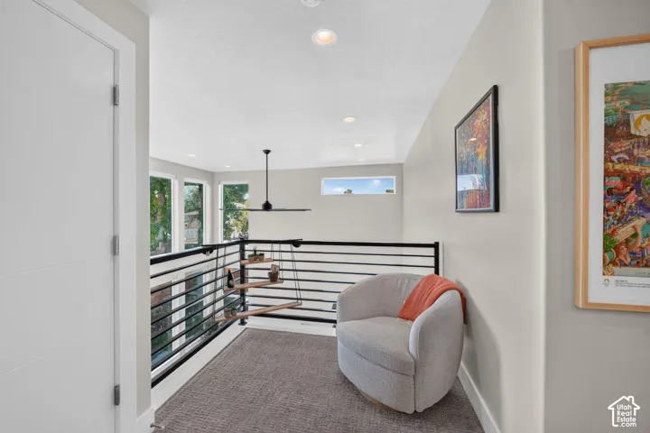 Upper-level landing featuring a contemporary horizontal railing, recessed lighting, and views into open concept living space