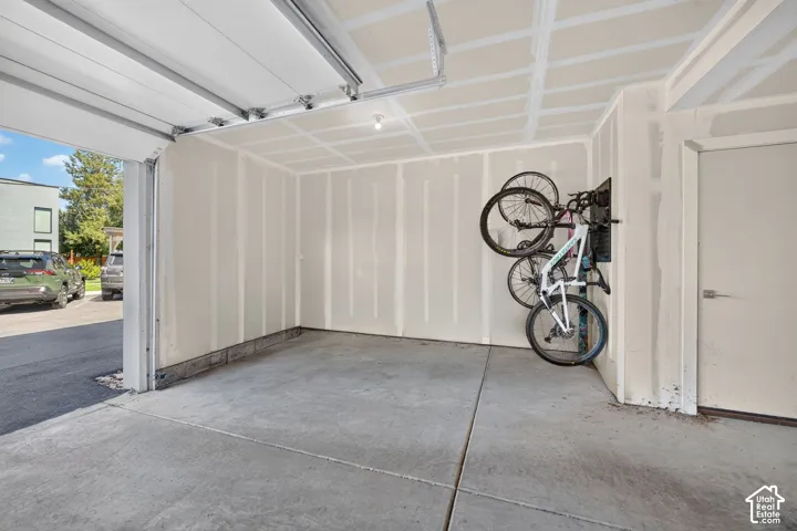 Concrete flooring, overhead lighting, and mechanical closet. Digitally altered to remove cars and packing boxes