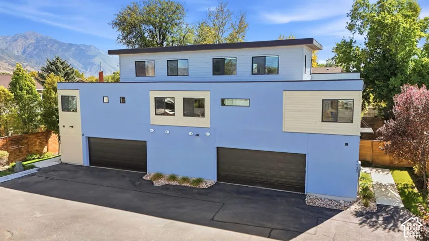 Contemporary multi-level exterior with a flat roofline and blue stucco siding