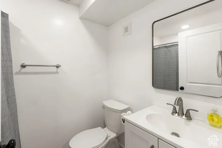 White vanity with brushed nickel hardware, undermount sink, and a framed rectangular mirror