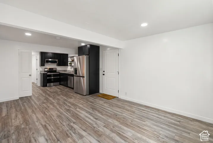 Kitchen area featuring black cabinetry, stainless steel appliances, and recessed lighting