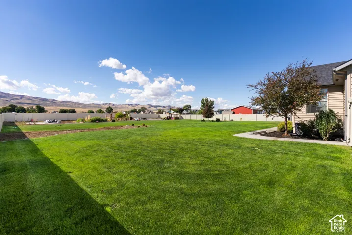 Expansive lawn with perimeter fencing and distant mountain scenery