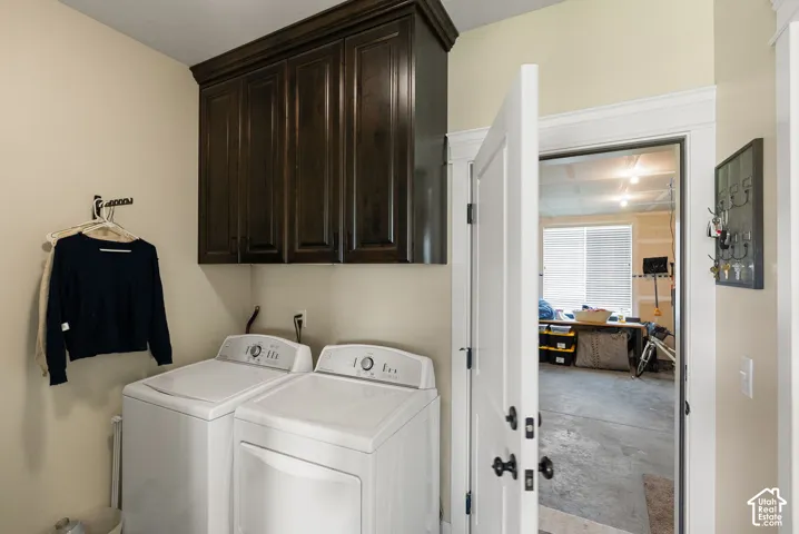 Dark wood-finish cabinetry provides storage above laundry appliances