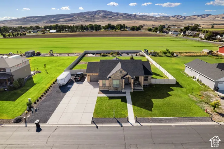 Single-story residence featuring a stone and siding exterior, concrete driveway, and a fenced backyard
