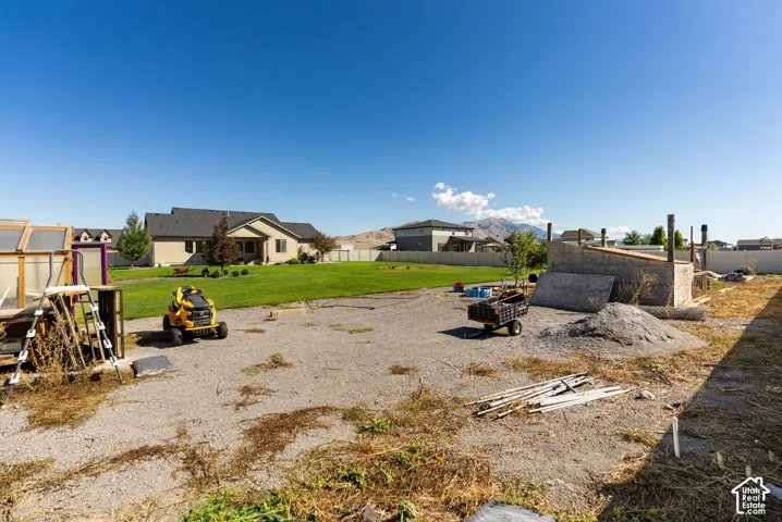 Gravel yard area with partial fencing and distant mountain scenery