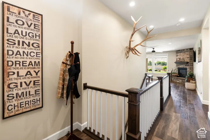 Wood-finish flooring throughout, with a stone-clad fireplace, and recessed ceiling lighting