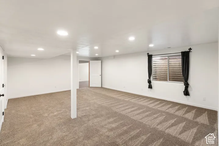 Spacious interior featuring recessed lighting, light-toned walls, and patterned carpeting