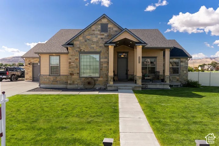 Stone and siding exterior with a covered porch entry