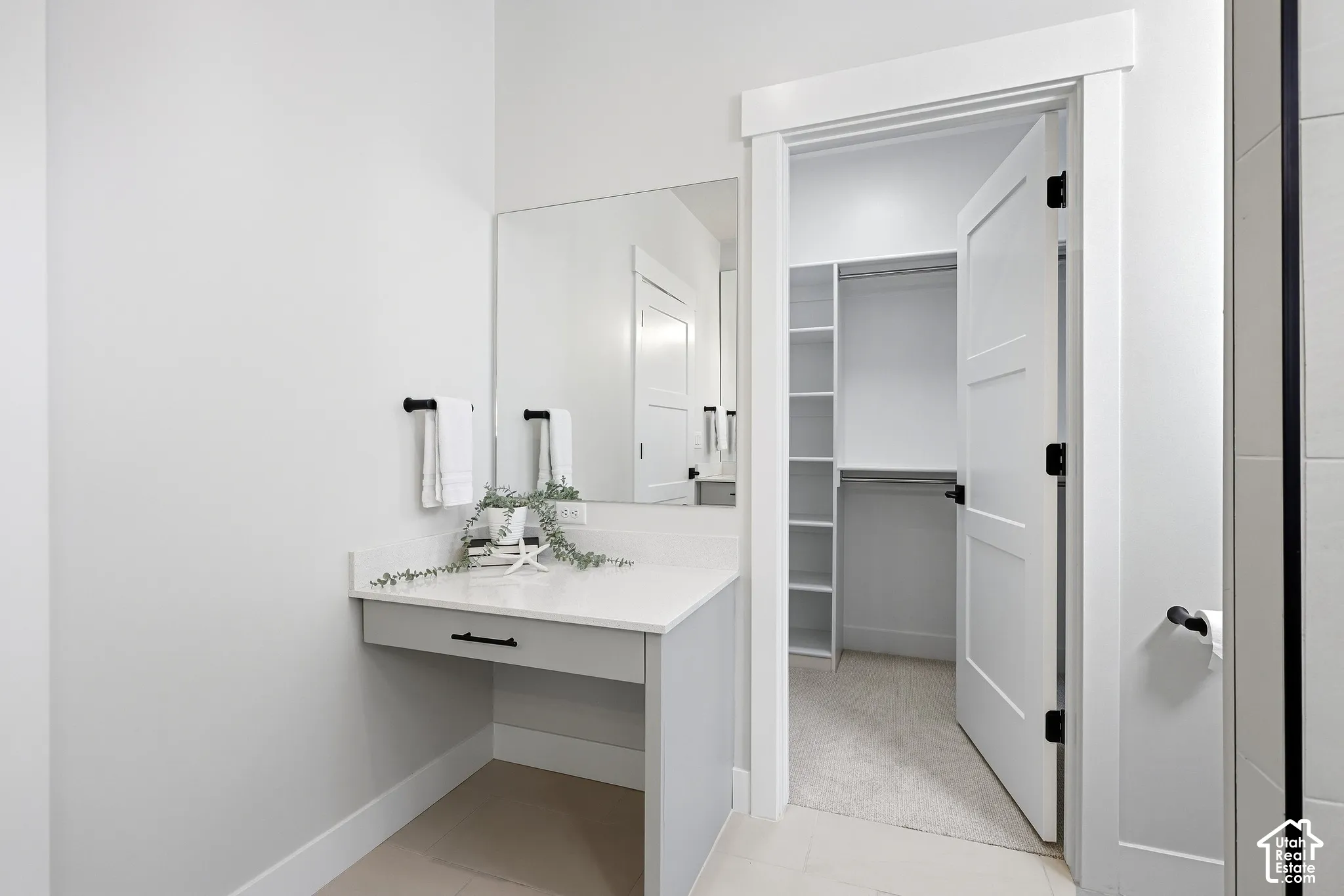 Primary bathroom with separate make up counter and walk in closet