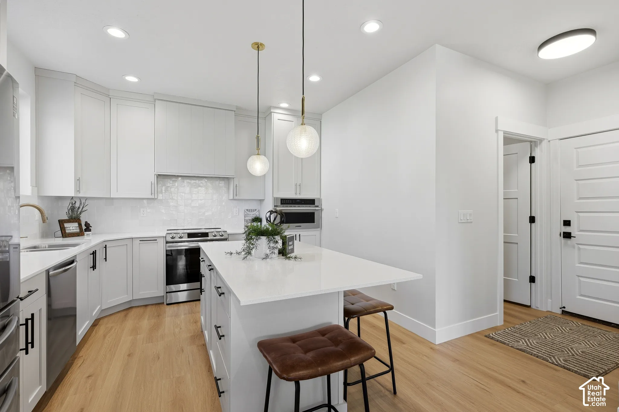 Gourmet kitchen with quartz countertops, stainless steel appliances, center island and large pantry