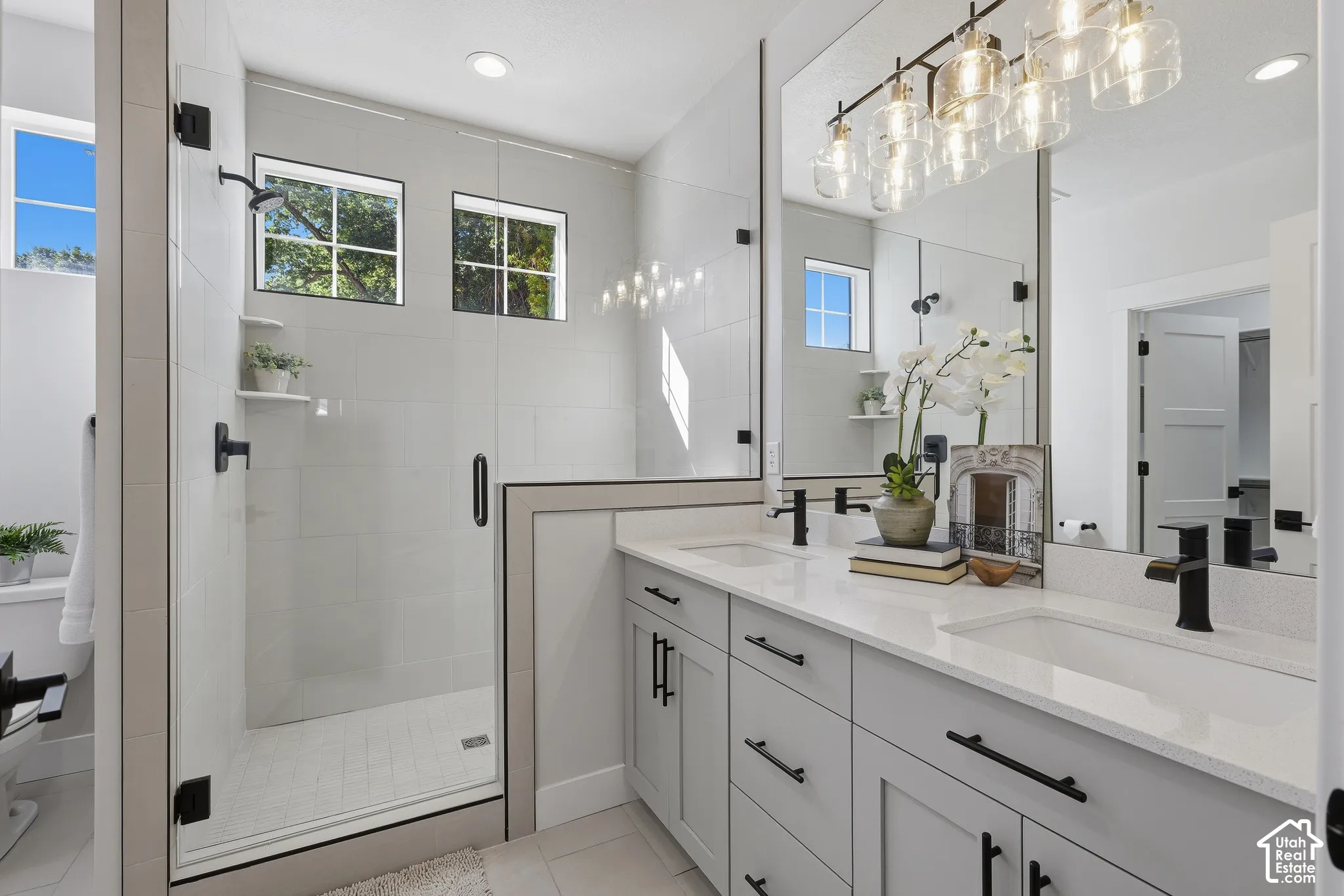Primary bathroom with dual vanities, separate makeup counter and oversized shower with euro glass