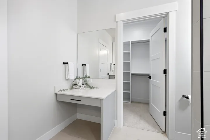 Primary bathroom with separate make up counter and walk in closet
