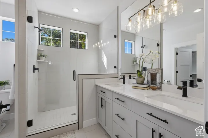 Primary bathroom with dual vanities, separate makeup counter and oversized shower with euro glass
