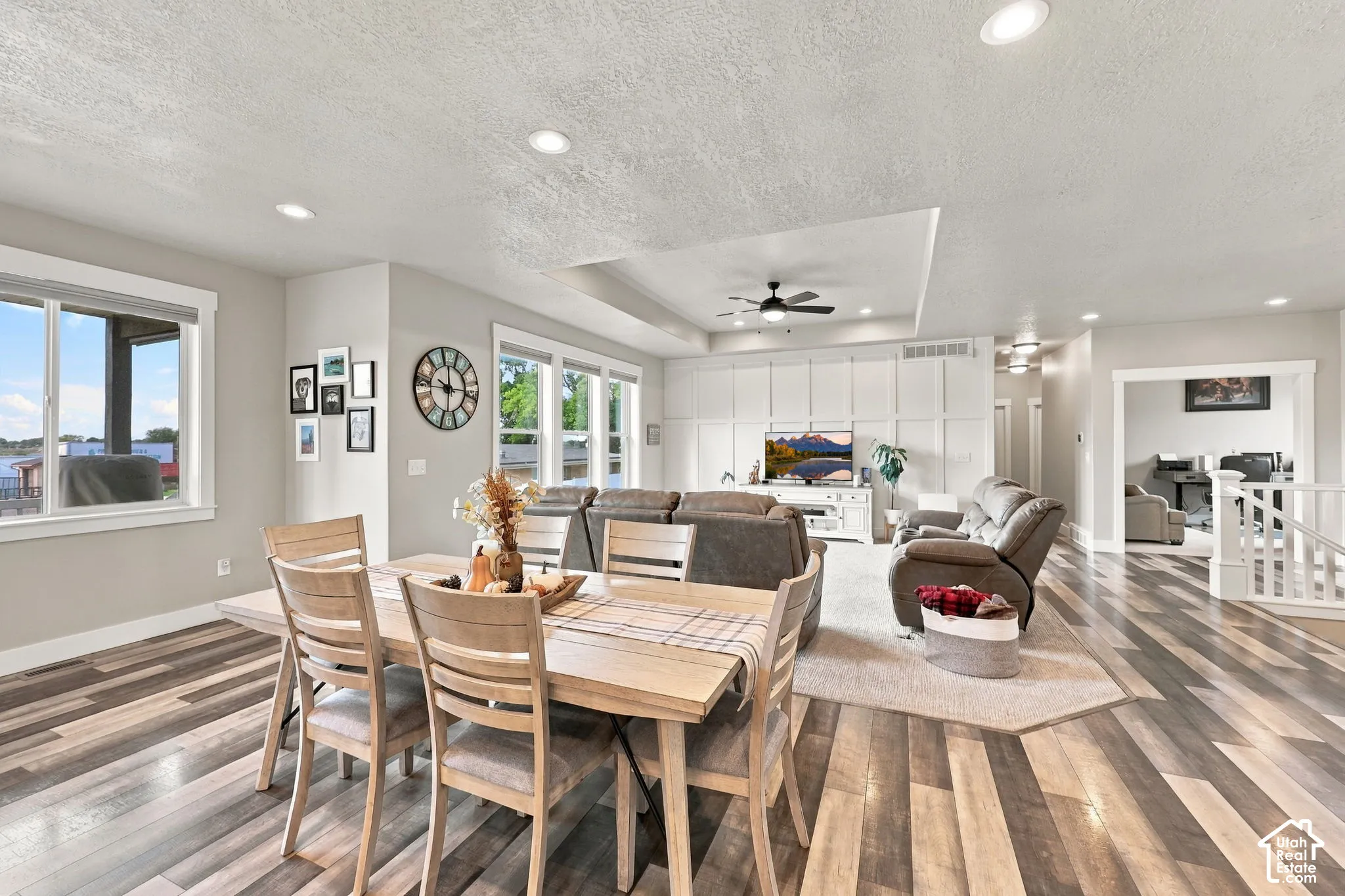 Recessed lighting, wood-finish flooring, multiple windows, built-in wall paneling, and an open layout