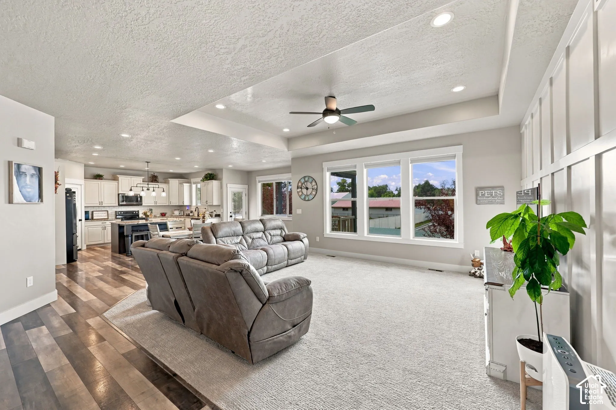 Spacious living area featuring carpet flooring, tray ceiling, and recessed lighting