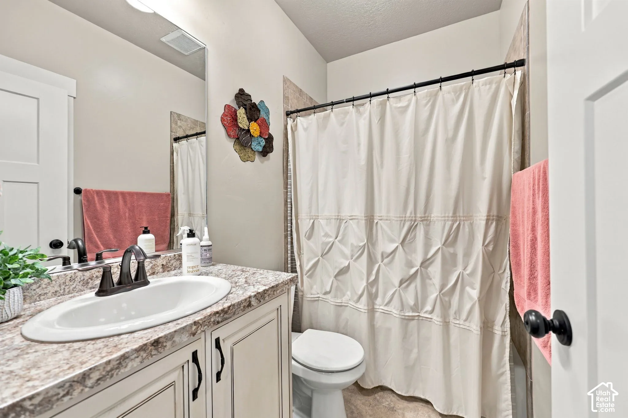 Vanity with an integrated oval sink, dark bronze faucet, and patterned countertop