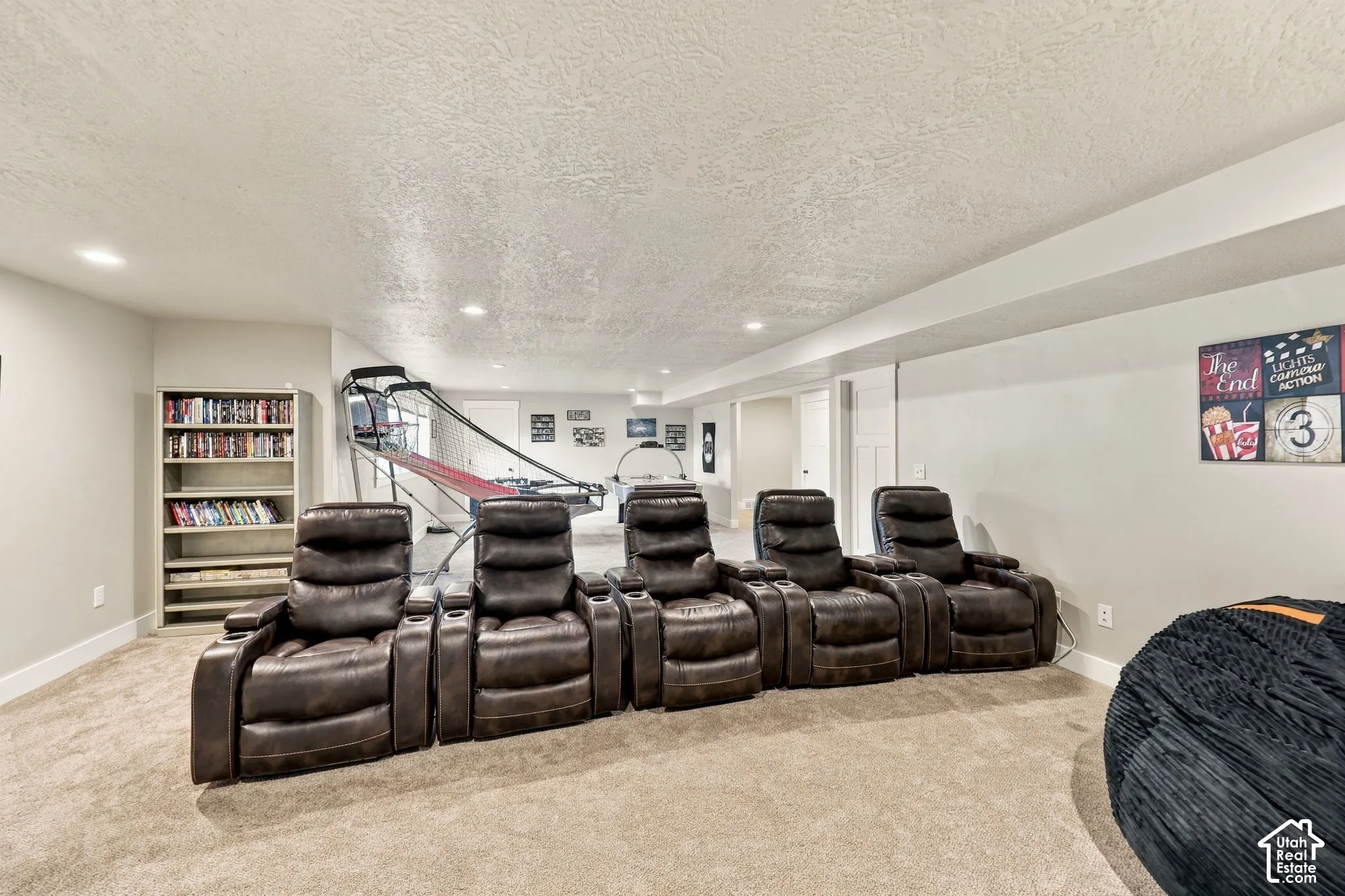 Recessed lighting illuminates a carpeted floor and light-toned walls