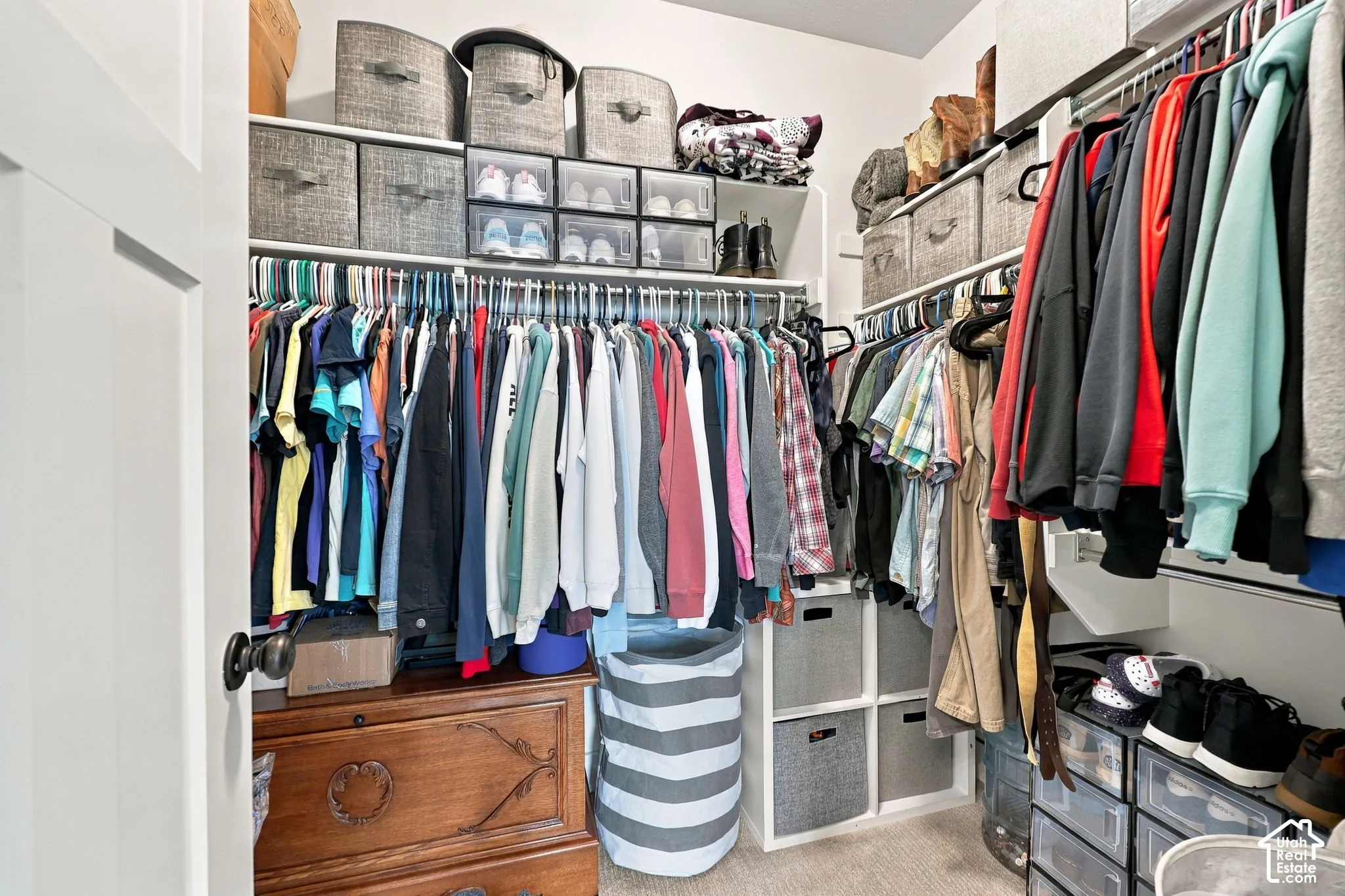Walk-in closet with multiple hanging rods, built-in shelving, and modular storage options